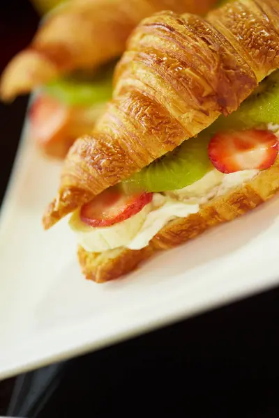 Croissant con frutta su piatto bianco — Foto Stock