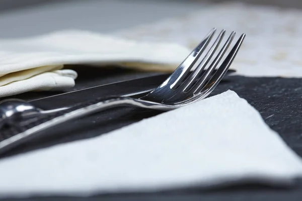 Veitsi ja haarukka pöydällä lautasliina — kuvapankkivalokuva