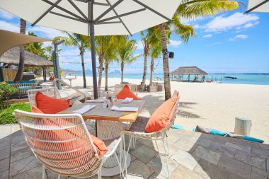 Tropikal tatil beldesinde yemek masaları