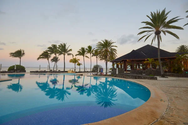 Luxury pool at sunset, tropical vacation.