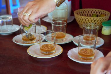 Masada servis edilen tabaklar ve kaşıklarla içecekler