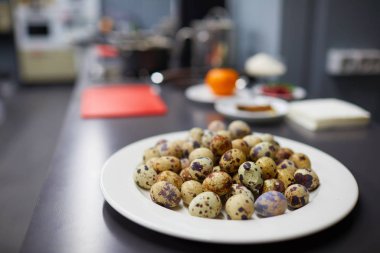 Benekli bıldırcın yumurtaları beyaz tabakta.