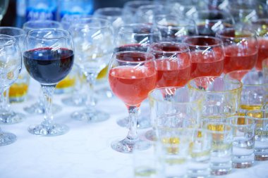 Beyaz masada bardaklarda servis edilen alkol içecekleri.