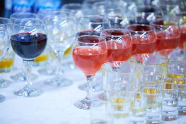 Beyaz masada bardaklarda servis edilen alkol içecekleri.