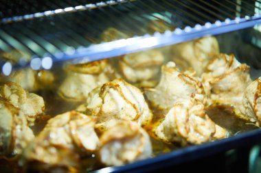 Et ruloları fırında şiş ile pişiriliyor.