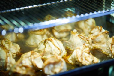 Et ruloları fırında şiş ile pişiriliyor.