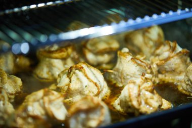 Et ruloları fırında şiş ile pişiriliyor.