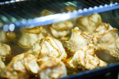 Et ruloları fırında şiş ile pişiriliyor.