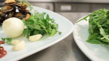 İçindekiler beyaz tabakta. balık, kabak, kiraz, karides, midye, mantar, soğan, sarımsak, otlar, maydanoz, limon, roka