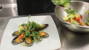 Akdeniz salatası roka yapraklı, domates ve midyeli.