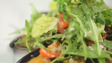 Akdeniz salatası roka yapraklı, domates ve midyeli.