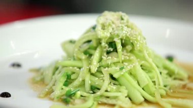 Beyaz tabakta susam tohumlu taze salatalık.