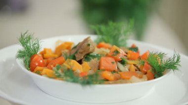 Sebzeli lezzetli sıcak salata ve beyaz kasede et.