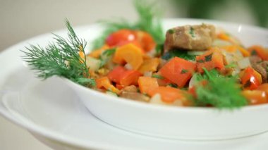 Sebzeli lezzetli sıcak salata ve beyaz kasede et.