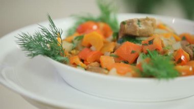 Sebzeli lezzetli sıcak salata ve beyaz kasede et.