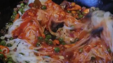 pirinç eriştesi, yeşil bezelye ve havuç, kırmızı sos, sarımsak ve soğan