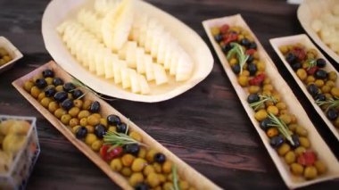 Restoranda çeşitli zeytinler ve peynir tabakları ile yemek masası. 
