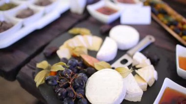 Aperatifler, peynirler, soslar, sebzeler ve meyveler açık büfe için masada.