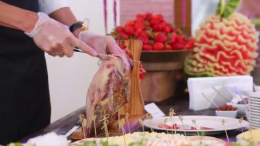Yakın çekim görüntüsü, el yapımı jamon eti bıçakla kesme ve tabakta servis etme