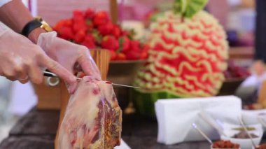 Yakın çekim görüntüsü, el yapımı jamon eti bıçakla kesme ve tabakta servis etme