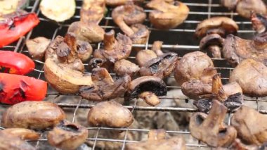 Mangal ızgarasında mantar, biber ve salatalık.