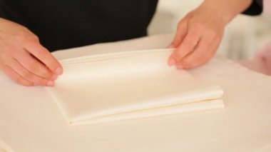 Kadın peçeteleri katlar, ziyafet hazırlar.