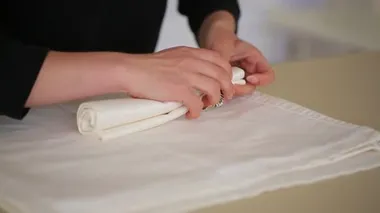 Kadın peçeteleri katlar, ziyafet hazırlar.