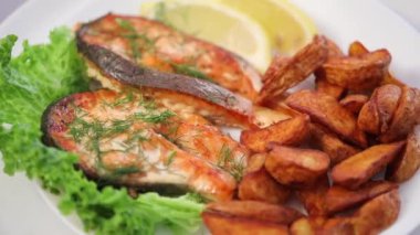 Lezzetli kızarmış patates ve kızarmış balık parçaları beyaz tabakta.