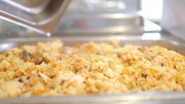 Şef pilavı kontrol etmek için gümüş yemek kabını açtı