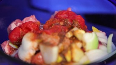 Şef sebzeyle eti mavi kasede karıştır, yakından bak.