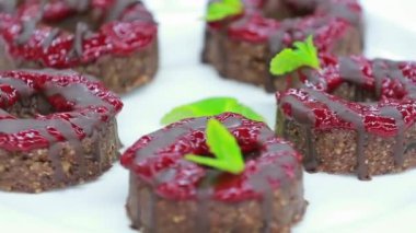 Çikolata soslu ve beyaz tabakta reçelli lezzetli keklerin yakın plan görüntüsü