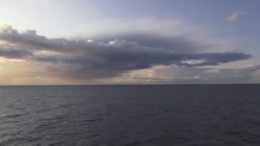 view from ship deck on setting sun above ocean timelapse