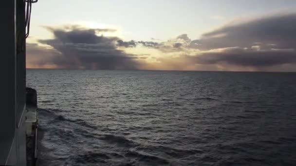 Θέα από το κατάστρωμα πλοίου ιστιοπλοΐα στον ωκεανό στο μαγευτικό ηλιοβασίλεμα — Αρχείο Βίντεο