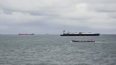 Büyük gemilere karşı denizde kargo taşıyan küçük bir tanker.