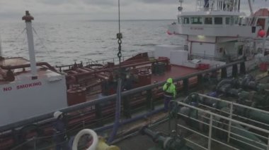 Güverte mürettebatı müşteri gemisine depolama için ürün hortumu verdi
