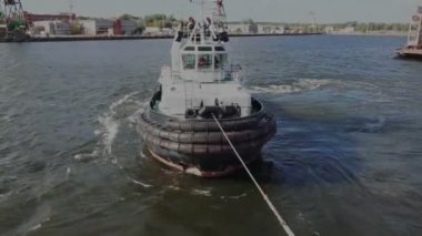 Römorkör, sakin limandan halatla petrol tankeri çekiyor.