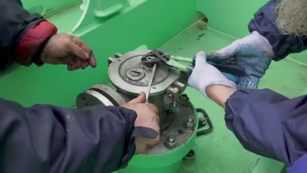 Ship mechanics fix stationary tank washer sleeve with pliers — Stockvideo