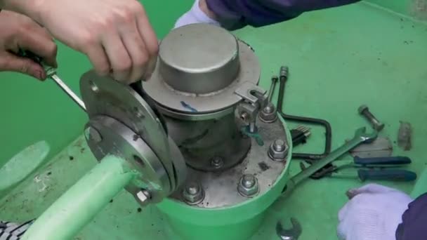 Mechanics mend stationary washer fixing disk to tube — Stock Video