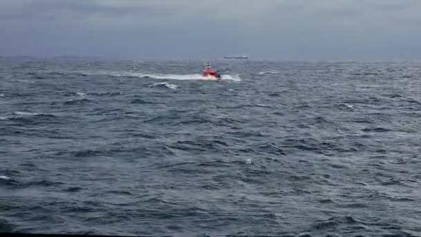 Pilot boat sails to oil tanker among grey waving sea — Stock Video