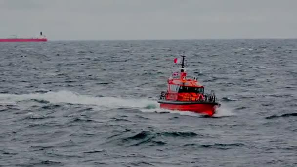 Яркая пилотная лодка плывет вдоль серой морской воды по портовым дорогам — стоковое видео