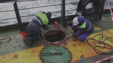 Mekanikler petrol tankeri güvertesinde kargo tankı kapağı pimlerini büker