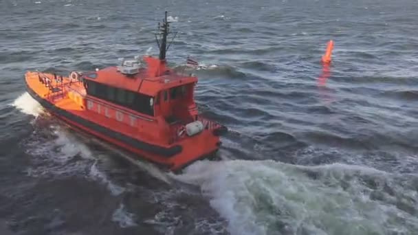 Orange pilot launch sails along sea water surface past buoy — Stock Video