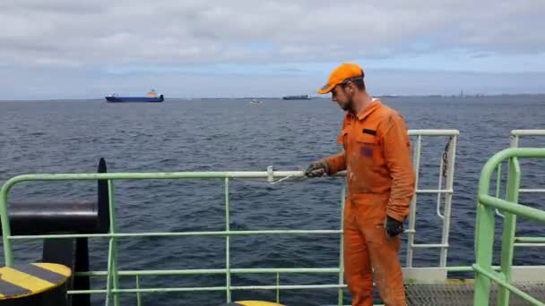 身穿橙色工作服的油轮水手在甲板上油漆栏杆 — 图库视频影像
