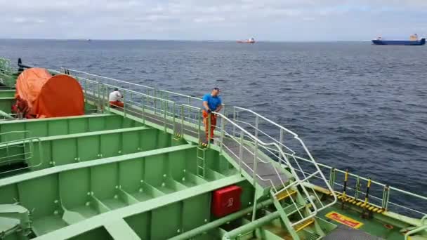 Marin travaille sur le pont contre les navires lointains sur le raid portuaire — Video