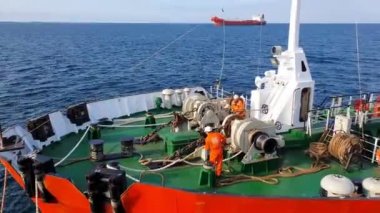 Mürettebat, denizdeki tankerlere karşı demirleme kablolarıyla çalışıyor.