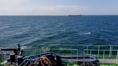 Onyx tanker sails on calm sea against ship drifting on raid