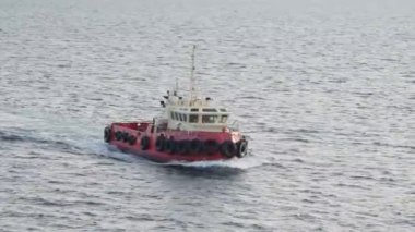 small towboat with tire protected boat sides sails on sea
