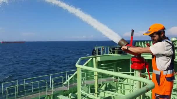 Tanker sailor washes deck with overboard water side view — 비디오
