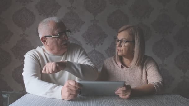 Starsza żona i mąż mówią o nowoczesnym, drogim urządzeniu — Wideo stockowe