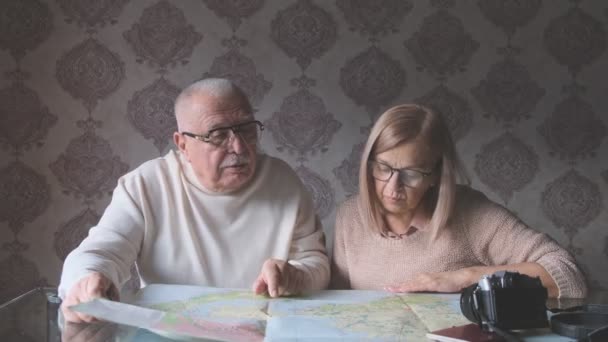 Senioren vrouw en echtgenoot ontdekken geografische kaart voor reizen — Stockvideo